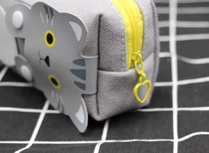 Vue détaillée d'une trousse en toile grise avec chat mignon et fermeture éclair cœur