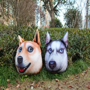 Vista detallada de cojines decorativos con forma de cabeza de perro 3D en hierba.