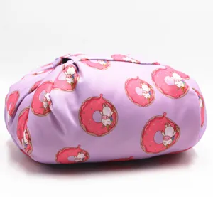 Vue latérale d'une trousse à maquillage violette à cordon avec motif de licorne
