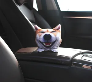 Primer plano de un peluche con cabeza de perro Shiba Inu y bolsa de carbón para coche
