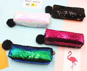 Detalle de los estuches de lentejuelas de sirena bicolor con suaves pompones negros