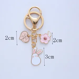 Detailed view of a cute pink rabbit keychain with heart and flower charms.