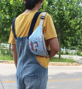 Foto de estilo de vida de una riñonera de lentejuelas azules con diseño de unicornio