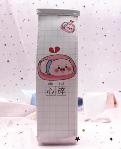 Primer plano de un lindo cerdito en un estuche blanco con patrón de cuadrícula.