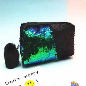 Vista detallada de un neceser de lentejuelas reversibles con un pompón negro suave.