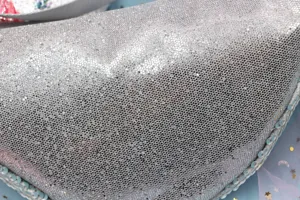 Primer plano detallado de lentejuelas plateadas y malla en una riñonera de moda