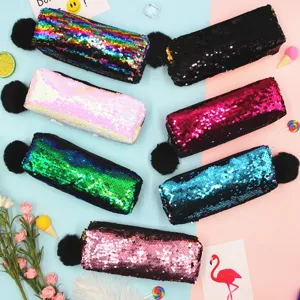 Estuches de lentejuelas reversibles de colores con pompones sobre fondo pastel