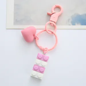 Close-up view of a cute pink heart and pastel building block keychain pendant charm