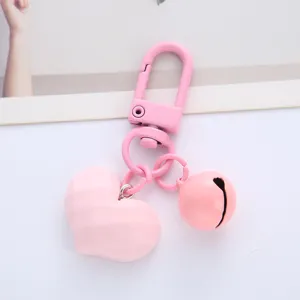 Detail view of a cute pink faceted heart keychain with a matching bell charm