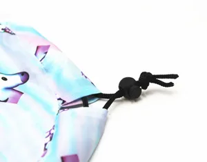Gros plan sur la fermeture à cordon et l'imprimé licorne sur le sac de rangement