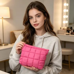 Primer plano de un neceser de maquillaje acolchado rosa vibrante sujeto por modelo
