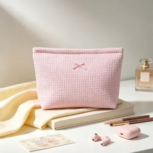Primer plano de un neceser rosa con textura de panal y un elegante lazo decorativo