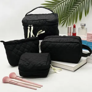 Juego de cuatro neceseres de maquillaje negros texturizados para viaje y cosméticos.