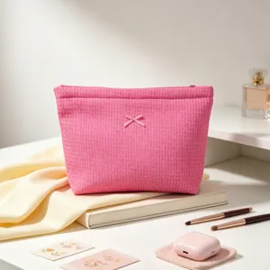 Bolsa de cosméticos rosa de nido de abeja con lazo en una escena elegante y fresca