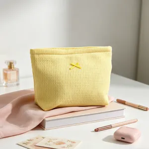 Primer plano detallado del neceser amarillo con textura de gofre y lazo pequeño