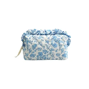 Gesteppte Kosmetiktasche mit blauem Blumenmuster und elegantem Rüschenrand