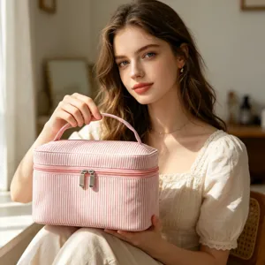 Gros plan d'une grande trousse de maquillage en seersucker à rayures roses tenue