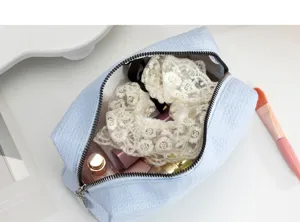 Detail van wafeltextuur make-uptas met grote binnenruimte en diverse accessoires