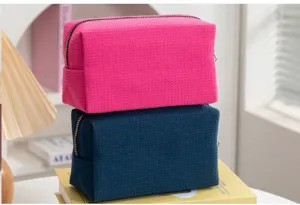 Detailopname van roze en donkerblauwe toilettassen met wafelstructuur
