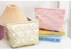 Neceser acolchado con motivos de corazones y lazos junto a varios libros decorativos
