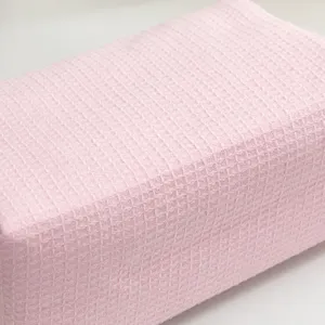 Detailopname van de zachte roze wafelstructuur van deze handige make-uptas.