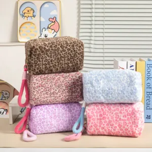 Variedad de neceseres de felpa con estampado de leopardo en un ambiente de vida acogedor.