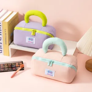 Soft marshmallow-style handheld cosmetic bags in pastel lavender and peach tones.