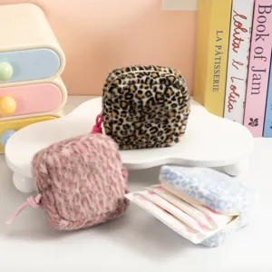 Detalle de neceseres de felpa con estampado de leopardo para compresas y cosmética.