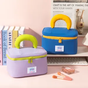 Vibrant blue and purple waterproof cosmetic bags with thick handles on a vanity setup