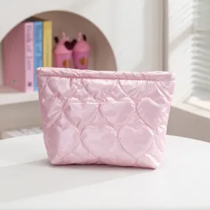 Detalle del neceser acolchado rosa con diseños de corazones en relieve suaves