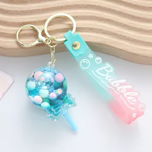 Detail view of a cute lollipop-shaped quicksand keychain with a colorful strap
