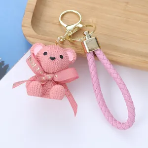 Close-up of pink knitted-texture resin bear keychain with braided wrist strap