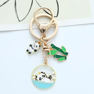 Detailed view of the cute panda and bamboo charms on a gold-toned creative keychain.