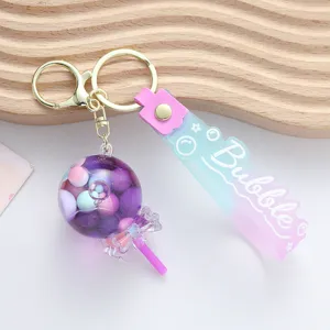 Close-up view of a purple liquid shaker lollipop keychain with embossed Bubble strap.