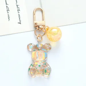 Macro detail of a colorful acrylic bear keychain with gradient crystal ball and gold clasp