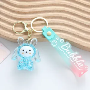 Detailed macro shot of a cute acrylic rabbit keychain with blue liquid and star sequins