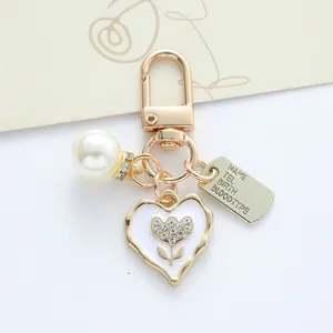 Detail shot of elegant heart-shaped keychain with crystal flower and pearl charm