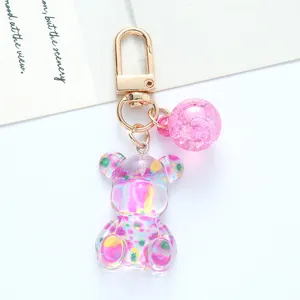 Close-up detail of a colorful gradient acrylic bear keychain with a gold metal clasp