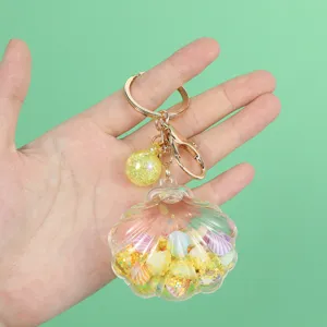 Close-up detail of a transparent shell keychain filled with liquid and colorful charms