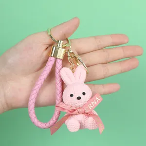 Detail showing the pink knitted-texture resin rabbit keychain with gold accents