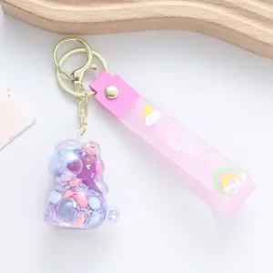 Close-up of cute pink unicorn oil floating bottle keychain with a wish silicone strap
