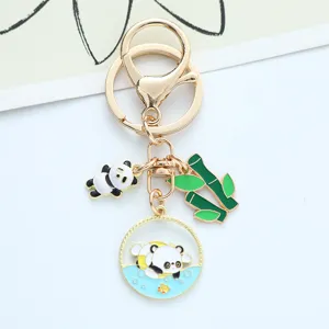 Close-up of cute enamel panda and green bamboo charms on a gold-plated keychain