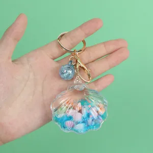 Detailed view of clear shell keychain with blue oil-filled quicksand and shells.