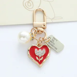 Close-up of handmade heart keychain with crystal flower and engraved metal tag