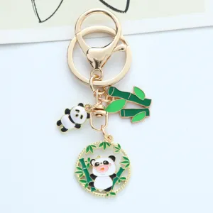 Detailed view of a cute panda and green bamboo enamel keychain with a golden lobster clasp.