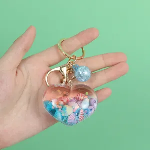 Close-up of heart-shaped liquid quicksand keychain with colorful shells and glitter