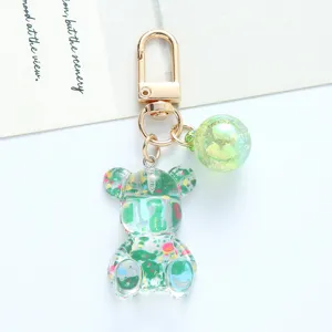 Close-up detail of a colorful acrylic bear keychain with a pearl-like sphere charm