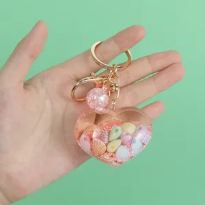 Close-up detail of the heart-shaped charm with internal seashells and glitter ball