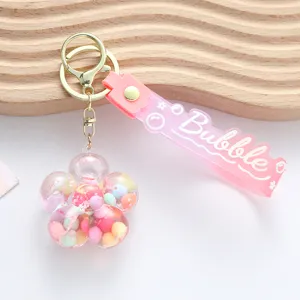 Detail of flower-shaped liquid keychain with colorful quicksand and pink wrist strap
