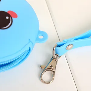 Gros plan d'un porte-monnaie en silicone bleu avec fermoir mousqueton en métal et dragonne